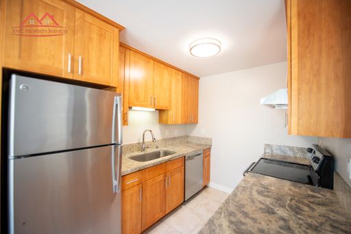 Kitchen with granite counters, stainless steel refrigerator, and dishwasher