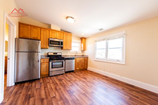 Kitchen with wood cabinets, stainless steel appliances, gas range, and laminate flooring at 272 Washington Street #5