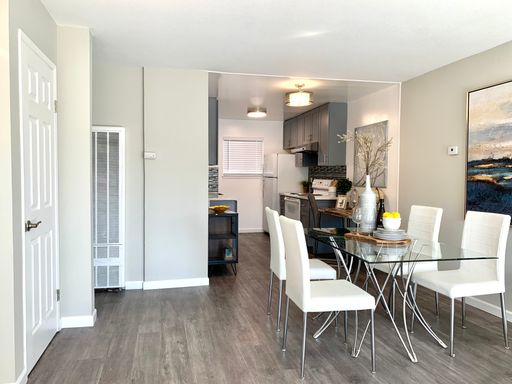 Dining area with laminate flooring opening to the kitchen (shown staged; rents unfurnished)