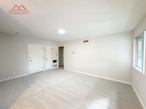 Bright living room with new carpet and large window at 411 College Avenue #B
