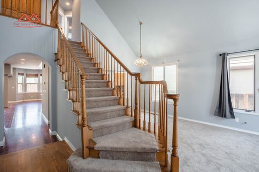 Entry with vaulted ceiling and hardwood staircase