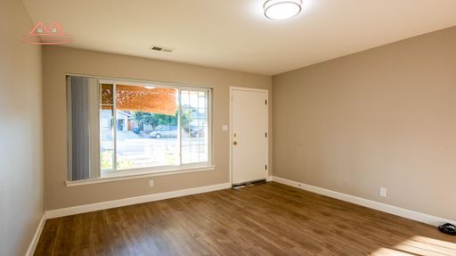 Bright living room with hardwood floors and large front window